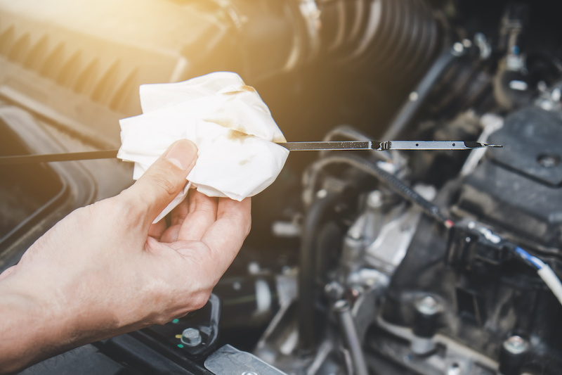 Services car engine machine concept, Automobile mechanic repairman hands checking a car engine automotive with oil level in the engine transportation, car service and maintenance.